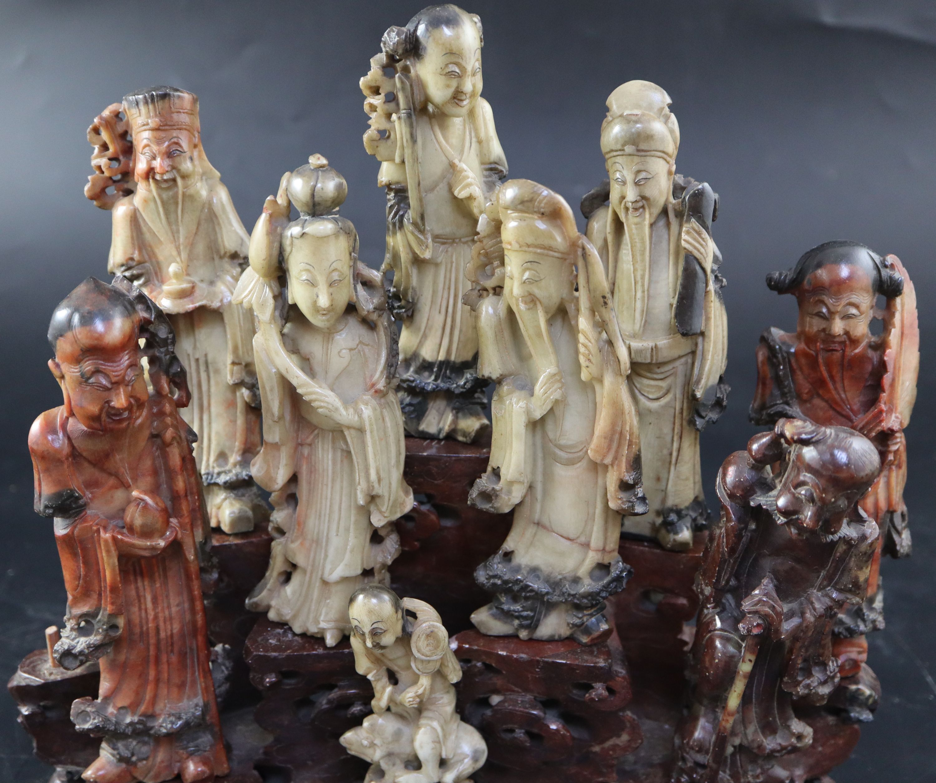 A group of nine Chinese Taoist carved coloured soapstone figures of immortals, width 29cm height 27cm